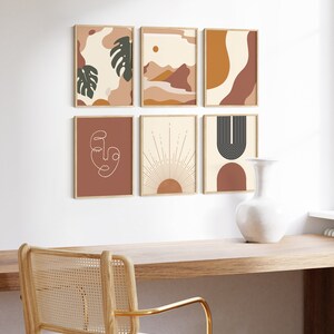 May include: Six minimalist abstract art prints in a gallery wall arrangement. The prints feature geometric shapes, line art, and organic forms in a warm colour palette of brown, orange, and cream. The prints are framed in natural wood frames and hung on a white wall.