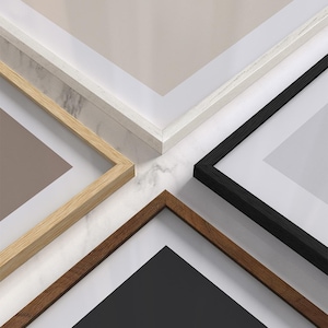 May include: Four picture frames with different colored wood frames. The frames are arranged in a cross pattern with the corners of each frame meeting in the center. The frames are on a white marble surface.