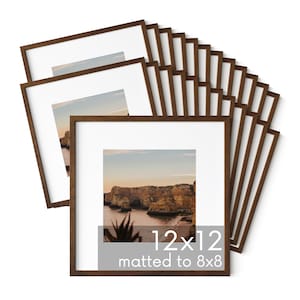 May include: A stack of 12 brown wood picture frames, each with a white mat and a clear glass front. The frames are 12x12 inches and matted to 8x8 inches.