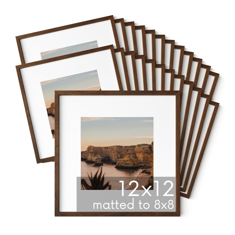 May include: A stack of 12 brown wood picture frames, each with a white mat and a clear glass front. The frames are 12x12 inches and matted to 8x8 inches.