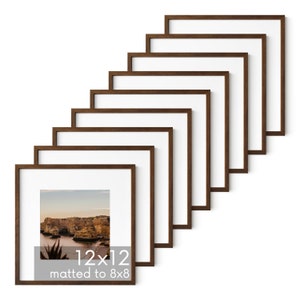 May include: Set of ten brown wood picture frames, each measuring 12x12 inches, with a mat to fit an 8x8 inch photo. The frames are stacked in a staggered pattern.