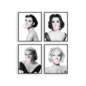May include: Four framed black and white portraits of iconic actresses, each blowing a pink bubble gum bubble. The portraits include Audrey Hepburn, Elizabeth Taylor, Grace Kelly, and Marilyn Monroe. The art pieces are displayed against a white background.