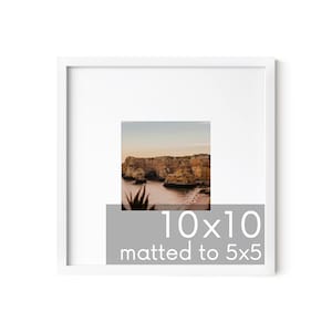 May include: A white picture frame with a 10x10 inch mat, showcasing a photograph of a rocky coastline with a sunset sky. The text "10x10 matted to 5x5" is printed on the bottom of the frame.
