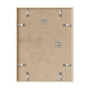 May include: The back of a light wood picture frame with metal hanging hardware. The frame is made of a light wood and has a simple design.