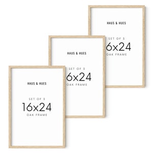 May include: Three framed art prints with light oak frames. The prints have white backgrounds with the text "HAUS & HUES" and "SET OF 3 6x24 OAK FRAME" or "SET OF 3 16x24 OAK FRAME" in black. The frames are 16 inches by 24 inches.