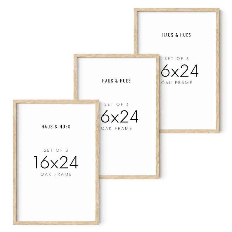 May include: Three framed art prints with light oak frames. The prints have white backgrounds with the text "HAUS & HUES" and "SET OF 3 6x24 OAK FRAME" or "SET OF 3 16x24 OAK FRAME" in black. The frames are 16 inches by 24 inches.