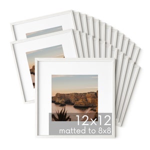 Op de afbeelding: Een stapel van 12 witte fotolijsten, elk met een afmeting van 30,5 x 30,5 cm en een passe-partout van 20,3 x 20,3 cm. De lijsten zijn in een waaier vorm gerangschikt, met de bovenste lijst licht naar voren gekanteld.