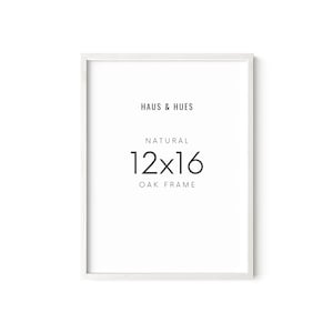 May include: White wood picture frame with the text "HAUS & HUES" "NATURAL" "12x16" "OAK FRAME" printed on it.