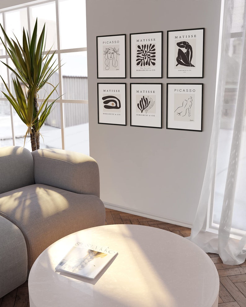 May include: A set of six black framed prints with white line drawings of abstract shapes and figures. The prints are arranged in a grid pattern on a white wall. The prints are titled "Picasso" and "Matisse".