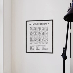 May include: Black and white framed print with the text "Forgot your phone?" and a word search puzzle with the words "shower, soap, bubbles, bathtub, toilet, towel, curl, shampoo, bodywash, hair, conditioner, toothbrush".