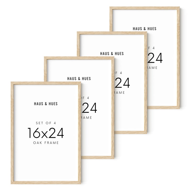 May include: Four rectangular oak picture frames, each with a white interior. The frames are arranged in a staggered formation. Text on the frames reads "HAUS & HUES", "SET OF 4", "16x24 OAK FRAME", and "24".