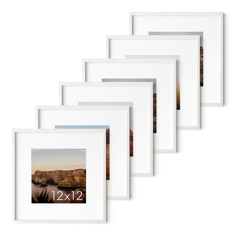 Op de afbeelding: Een set van zes witte fotolijsten, elk met een witte passe-partout, in een verspringende opstelling. De lijsten zijn 30,5 x 30,5 cm en bevatten verschillende landschapsfoto's.