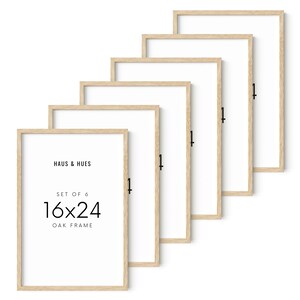 May include: Set of six 16x24 inch oak frames with white interiors. The frames are arranged in a diagonal pattern, showcasing their light wood grain and simple design. The text "HAUS & HUES" and "OAK FRAME" are printed on the front.