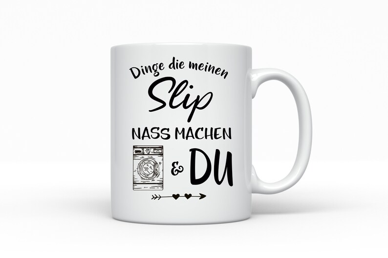 May include: White ceramic mug with a black design that says "Dinge die meinen Slip nass machen & DU" with a drawing of a washing machine and an arrow with hearts.