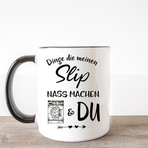 May include: White ceramic mug with a black handle. The mug has a black graphic that says "Dinge die meinen Slip nass machen & DU" with a drawing of a washing machine and arrows with hearts.