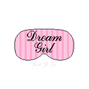 May include: A pink and white striped sleep mask featuring the black text Dream Girl in a cursive font. The sleep mask has a rounded, contoured shape with a pixelated border. Below the mask, the text Thread The Fan is written in a light pink script.