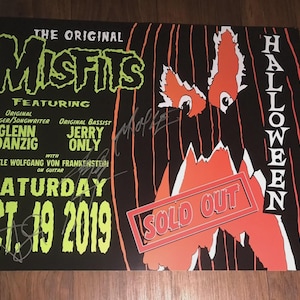 May include: Black and orange concert poster for The Original Misfits Halloween show, featuring Glenn Danzig and Jerry Only. The poster includes the date, "Oct. 19 2019," and the text "Sold Out."