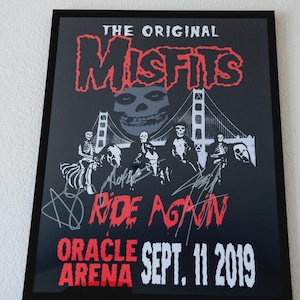 May include: Black framed poster featuring "The Original Misfits" band. The poster includes a skull graphic, a bridge, and the text "Ride Again" in red. The date "Sept. 11 2019" is also visible.