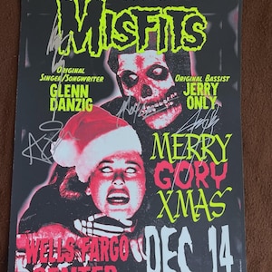 May include: A concert poster for The Misfits, featuring a skull and a woman in a Santa hat. The poster has the text "MERRY GORY XMAS" and "DEC. 14". The names Glenn Danzig and Jerry Only are also visible.