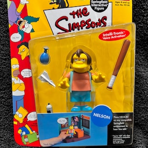 May include: A packaged "The Simpsons" Nelson action figure. The figure is yellow with brown hair, wearing a blue shirt and shorts. Accessories include a baseball bat, a water bottle, and a paper airplane. The packaging includes the text "World of Springfield Interactive Figure".