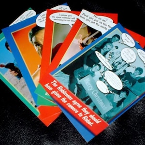 May include: A set of six Christmas cards featuring humorous holiday greetings. The cards are decorated with blue, red, and green colors and feature various images, including a group of people, a man with a gun, and a man with a beard. The text on the cards includes phrases like "Merry Christmas" and "The Robinsons agree they should have given the camera to Robot."
