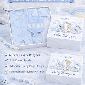 May include: A six-piece baby gift set in a white box, featuring a blue teddy bear design on the clothing. The box includes the text "Born In" and "Baby Thompson". The set includes a bib, hat, mittens and a onesie.