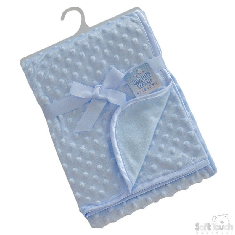 May include: A light blue baby blanket with a satin trim and a white tag that says "Soft Touch Infants Wrap  Big & Soft". The blanket is tied with a light blue satin ribbon.