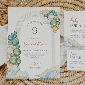 May include: A baby shower invitation featuring a watercolour design of clouds and balloons in shades of blue, green, and gold. The invitation reads "We're on Cloud 9 Honoring Vera and Prince Saturday, October 17 at 1 PM 103 Bohemian Ln. Palm Beach CA Kindly RSVP to Jane by 20.05 000.000.0000 Registered at Target & Amazon". There are also cards for a nappy raffle and a request for books instead of cards.