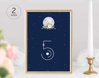 May include: A framed print with a navy blue background featuring a white number 5 with an arrow design. A full moon with floral accents is at the top. The text "2 SIZES" is in a circle in the upper left corner. The text "ANE DESIGN BOUTIQUE on Etsy" is at the bottom.