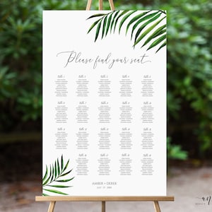 May include: A white wedding seating chart with a tropical theme. The chart features a green palm leaf design and the text "Please find your seat". The chart lists tables 1 through 18 with guest names. The bottom of the chart reads "Amber + Derek July 21, 20XX".