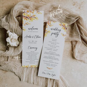 May include: A wedding ceremony program with a watercolor design of fall leaves in shades of yellow and orange. The program includes the names of the wedding party and the order of the ceremony. The text reads "Welcome to our wedding, Amber & Ethan, July 20, 20XX, Botanical Garden, Ceremony, Prelude, Bridesmaids Processional, Bridal Processional, Welcome Prayer, Exchange of Vows, Exchange of Rings, Declaration of Marriage, Blessings, Presentation of the Couple, Recessional, Wedding Party, Officiant, Parents of the Bride, Parents of the Groom, Maid of Honor, Best Man, Bridesmaids, Groomsmen, Ushers, Flower Girl, Ring Bearer, With love and thanks, Mr. & Mrs. Taylor."