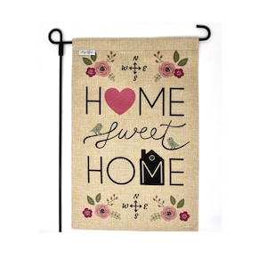May include: A burlap garden flag with a pink heart and the text "Home Sweet Home" in black. The flag also features a compass rose, flowers, and birds.
