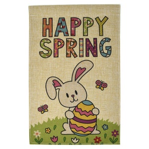 Peut inclure: Un drapeau de jardin en toile de jute avec le texte "Happy Spring" en lettres colorées. Un lapin blanc tenant un œuf de Pâques rayé se trouve en bas au centre du drapeau. Il y a des papillons et des fleurs sur le drapeau.