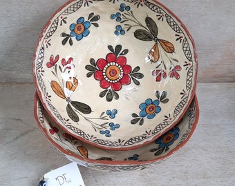 Pode incluir: Duas tigelas de cerâmica empilhadas com fundo branco e desenhos florais coloridos. As tigelas têm uma borda marrom e uma borda com padrão marrom e branco. As tigelas são feitas por Didem First Ceramics.