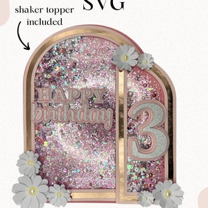 May include: Pink and gold glitter cake topper with a shaker topper included. The topper features a pink and gold arch with the words "Happy Birthday" and the number "3". The topper also includes white daisies.