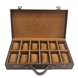 May include: Open brown leather watch case with a handle and metal clasps. The interior is lined with a tan fabric and features 12 individual compartments for storing watches. The case is designed to protect and organize timepieces.