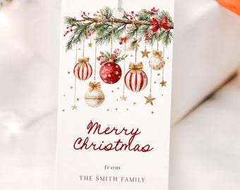 May include: A white gift tag with a Christmas ornament design. The tag features watercolor illustrations of red and gold ornaments, greenery, and the words "Merry Christmas" in red script. The tag also includes "from THE SMITH FAMILY".