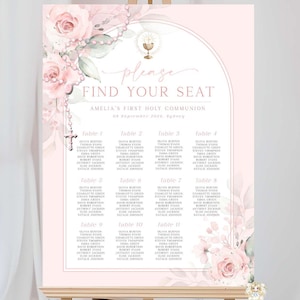 May include: A pink and white seating plan for Amelia's First Holy Communion, displayed on a wooden easel. The chart features floral accents, a cross, and the words "Please Find Your Seat."