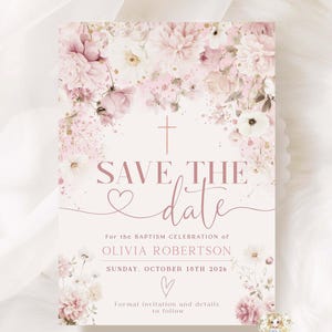 May include: A pale pink invitation card featuring floral decorations and the words "SAVE THE date". The invitation is for Olivia Robertson's baptism, set for Sunday, October 18th, 2026. The design includes pink and white flowers.