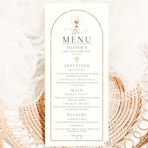 Könnte beinhalten: Eine Menükarte zur Erstkommunion mit einem goldenen Bogenrahmen und eleganter Schrift. Die Speisekarte umfasst Vorspeisen, Hauptgerichte wie Lachsfilet und Desserts. Die Karte liegt auf einem geflochtenen Korb.
