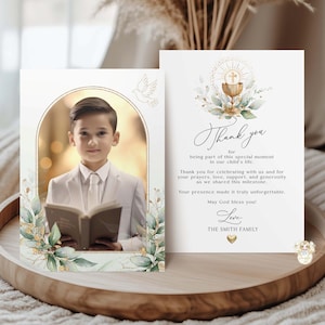 Peut inclure: Un ensemble de faire-part et de cartes de remerciement pour la Première Communion. L'invitation présente un garçon en costume blanc tenant un livre, encadré d'or et de verdure. La carte de remerciement a une écriture élégante et des accents floraux.