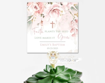 Puede incluir: Un diseño floral rosa y dorado con una cruz y el texto "Faith plants the seed, love makes it grow." También se incluye el texto "Emily's Baptism 05/25/2025". Este diseño es para un favor de bautismo.