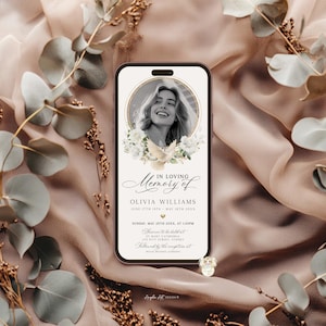 May include: A smartphone screen displays a memorial graphic. The design features a portrait of a woman, surrounded by white flowers and a dove. Text reads "In Loving Memory of Olivia Williams" with dates and event details. The background is a soft, draped fabric.
