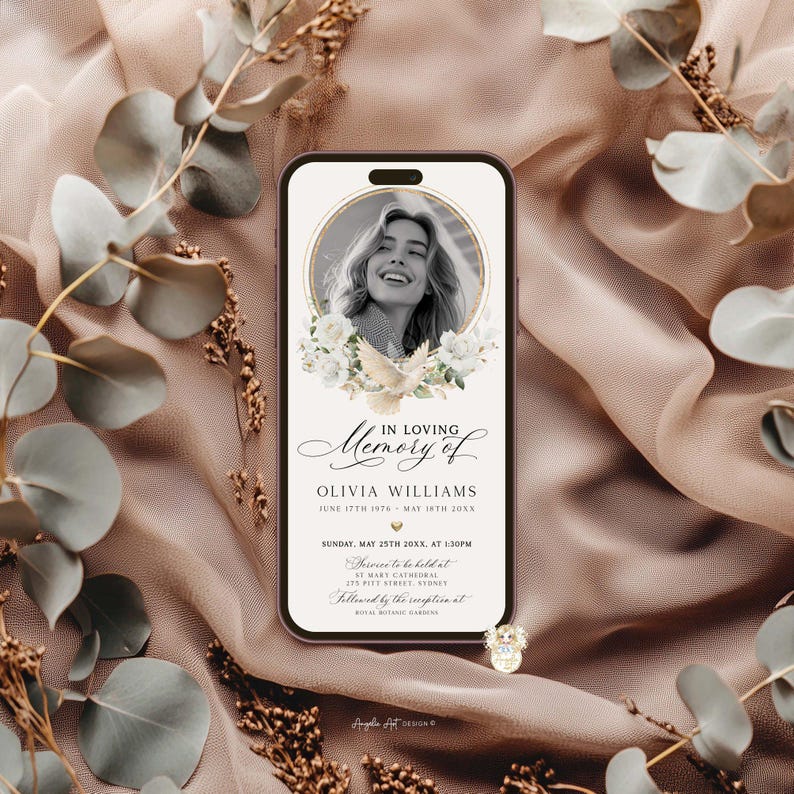 May include: A smartphone screen displays a memorial graphic. The design features a portrait of a woman, surrounded by white flowers and a dove. Text reads "In Loving Memory of Olivia Williams" with dates and event details. The background is a soft, draped fabric.