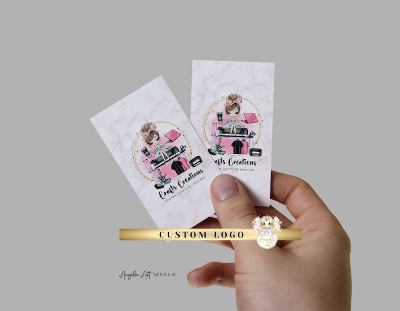 K&ouml;nnte beinhalten: Eine rosa und goldene Visitenkarte mit einem individuellen Logo, das ein Cartoon-M&auml;dchen zeigt, das auf einem Stapel Bastelutensilien sitzt. Der Text auf der Karte lautet "Crafts Creations Custom Crafts by Jennifer".