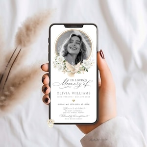 May include: A smartphone displays a memorial announcement. The design features a photo of a woman in a gold frame, surrounded by white flowers and a dove. Text includes "In Loving Memory of Olivia Williams" and event details.