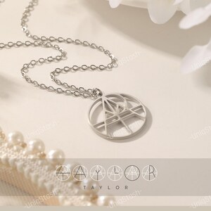Custom name logo necklace: round minimalist monogram nameplate pendant in stainless steel on a delicate silver chain.