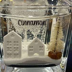 Gel Wax Candle with Tiny Houses and Christmas Tree embeds. Middle Glass Candle is Scented Cinnamon