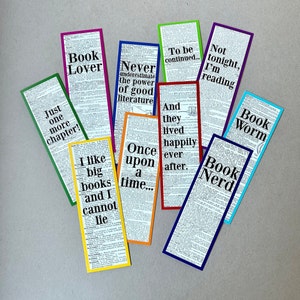 Può includere: Un set di dieci segnalibri colorati con diverse citazioni a tema libro. I segnalibri sono realizzati con pagine di dizionario con testo nero e un bordo colorato. Le citazioni includono "Book Lover", "Book Worm", "Book Nerd", "Just one more chapter", "I like big books and I cannot lie", "Never underestimate the power of good literature", "To be continued", "And they lived happily ever after", "Once upon a time", e "Not tonight, I'm reading".