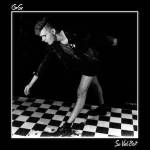 Könnte beinhalten: Schwarzweißfoto einer Person in Lederjacke und Shorts, die auf einem schwarz-weiß karierten Boden steht. Der Text "So Viel Zeit" ist unten in weiß auf dem Bild geschrieben.